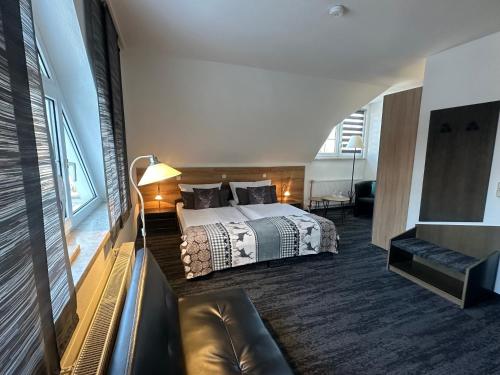 a hotel room with a bed and a couch at Hotel Bergschlößchen in Pockau