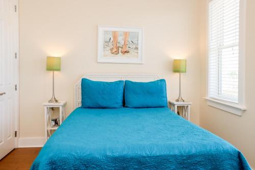 a bedroom with a blue bed with two lamps at Waterside Village Cottage 3220 by Pristine Properties Vacation Rentals in Mexico Beach
