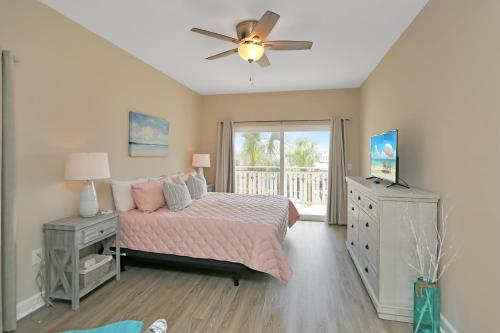 a bedroom with a bed and a ceiling fan at Waterside Village Condo 203 by Pristine Properties Vacation Rentals in Mexico Beach