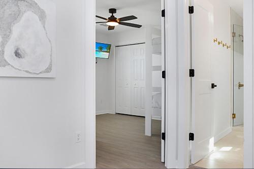 a white room with a ceiling fan and a hallway at The Ricks Carlton by Pristine Properties Vacation Rentals in Mexico Beach