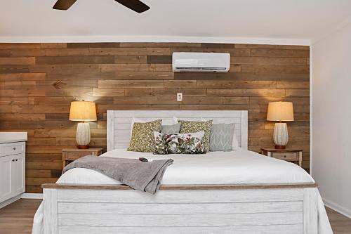 a bedroom with a white bed and wooden wall at The Ricks Carlton by Pristine Properties Vacation Rentals in Mexico Beach