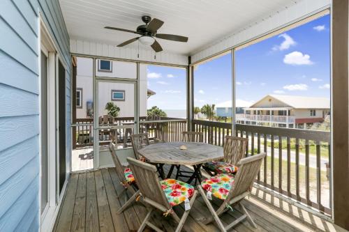 a porch with a table and chairs and a ceiling fan at Beach Please by Pristine Properties Vacation Rentals in Indian Pass