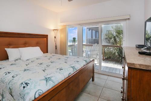 a bedroom with a bed and a balcony at Beach Please by Pristine Properties Vacation Rentals in Indian Pass