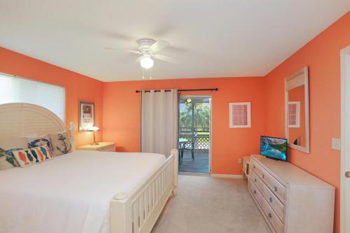 a bedroom with orange walls and a bed and a sliding glass door at Boardwalk Sandpiper by Pristine Properties Vacation Rentals in Cape San Blas