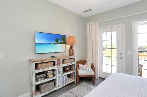 a bedroom with a tv on a white wall at Bethany Cottage by Pristine Properties Vacation Rentals in Indian Pass