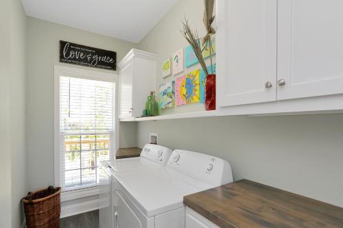 a kitchen with white cabinets and a white washer at Bethany Cottage by Pristine Properties Vacation Rentals in Indian Pass