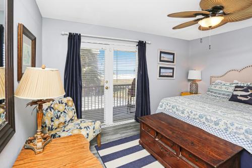a bedroom with a bed and a chair and a window at Flamingo Roost by Pristine Properties Vacation Rentals in Indian Pass