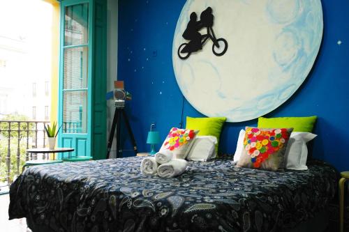 a room with a bed, a table and a painting on the wall at Sevilla Kitsch Hostel Art in Seville