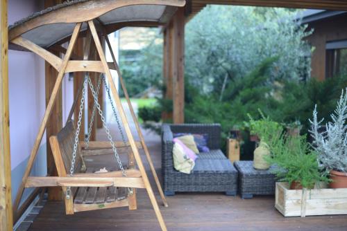 a porch with a swing and a couch on a patio at Dolce Casetta in Faenza