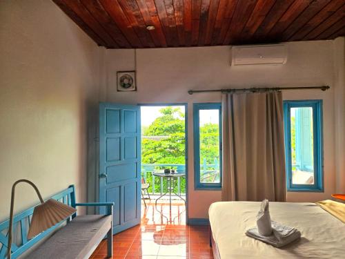 a bedroom with a bed and a door and a patio at west water hostel in Ban Khouaphan