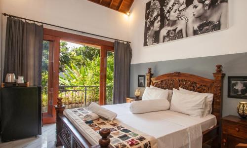 a bedroom with a bed and a balcony at Pondok Taksu Bali in Kuta
