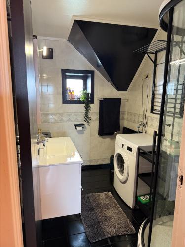 a bathroom with a sink and a washing machine at Leilighet med sydvendt balkong in Ålesund