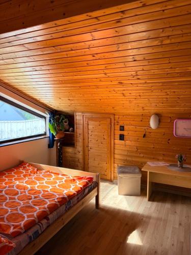 a bedroom with a bed and a wooden ceiling at Jesolo Apartmanház in Balatonkeresztúr