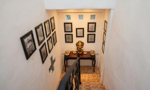 a hallway with a table and pictures on the wall at Pondok Taksu Bali in Kuta