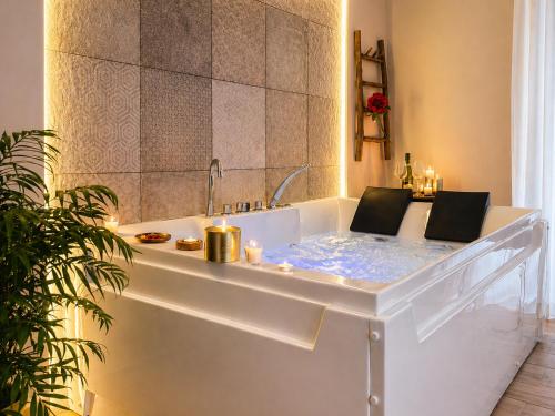 a bathtub with candles in it in a bathroom at Ciatu Miu Spa Suite Gambino in Carini