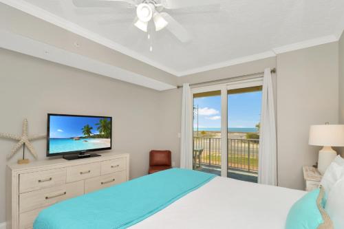 a bedroom with a bed and a flat screen tv at Summerhouse 106 by Pristine Properties Vacation Rentals in Mexico Beach