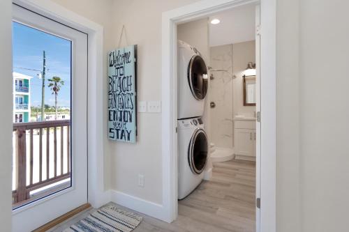 a laundry room with a washer and dryer next to a window at Beach Fantasies B by Pristine Properties Vacation Rentals in Mexico Beach
