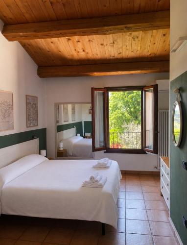 a bedroom with two beds and a large window at Locanda Merlaschio in Faenza