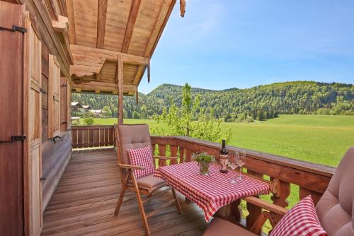 a wooden deck with a table and chairs on it at Chalet Menkenhof in Reit im Winkl