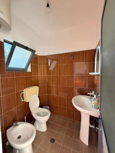 a bathroom with a toilet and a sink at Hotel Bar Restaurant MANI in Velipojë