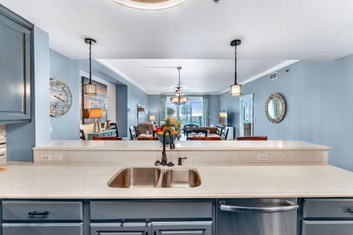 a kitchen with a sink and a living room at Summerhouse 101 - Pearl of the Gulf by Pristine Properties Vacation Rentals in Mexico Beach