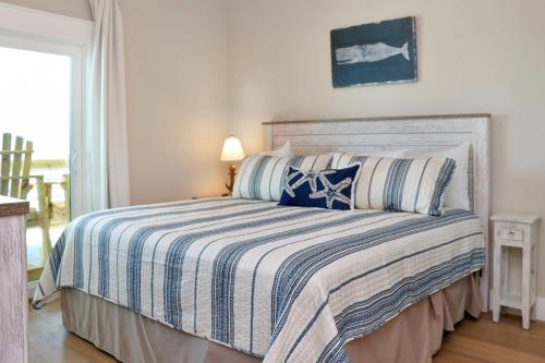 a bedroom with a bed with a striped comforter at The Great White 2 by Pristine Properties Vacation Rentals in Beacon Hill