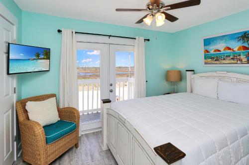 a bedroom with a bed and a chair and a window at Edgewater Retreat by Pristine Properties Vacation Rentals in Cape San Blas