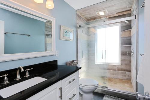 a bathroom with a toilet and a sink and a shower at Pelican Crossing by Pristine Properties Vacation Rentals in Cape San Blas