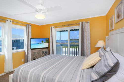a bedroom with a bed and a balcony with a television at Pelican Crossing by Pristine Properties Vacation Rentals in Cape San Blas