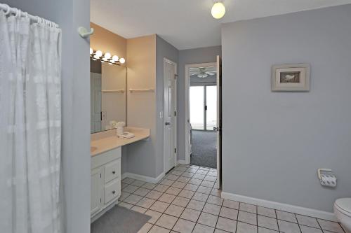 a bathroom with a sink and a toilet and a mirror at Pelican Landing 3 by Pristine Properties Vacation Rentals in Indian Pass