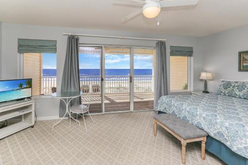 a bedroom with a bed and a television and a balcony at Pelican Landing 2 by Pristine Properties Vacation Rentals in Indian Pass