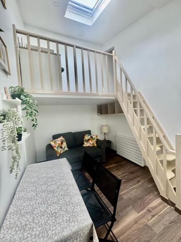 a living room with a staircase and a table at Maisonnette au calme-proche Métro in Maisons-Alfort