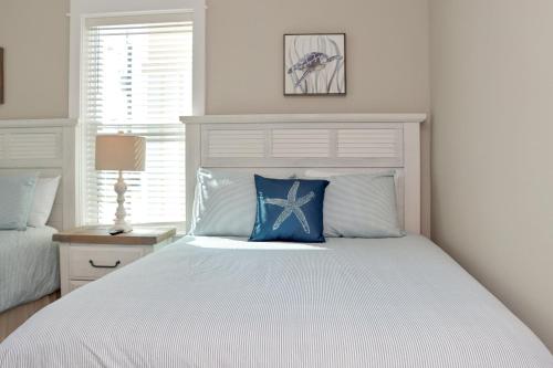 a white bedroom with a bed with a blue pillow at The Great White 1 by Pristine Properties Vacation Rentals in Beacon Hill