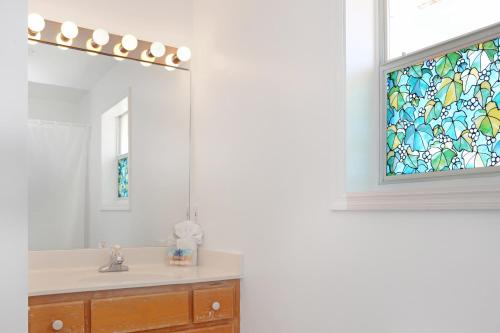 a bathroom with a sink with a stained glass window at Flamingo Dunes by Pristine Properties Vacation Rentals in Saint Joe Beach