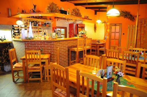 a restaurant with wooden tables and chairs and a bar at Penzion Severka in Smržovka