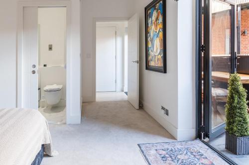 a bedroom with a bed and a bathroom at Stylish 2BR Flat by Richmond Park in Kingston upon Thames