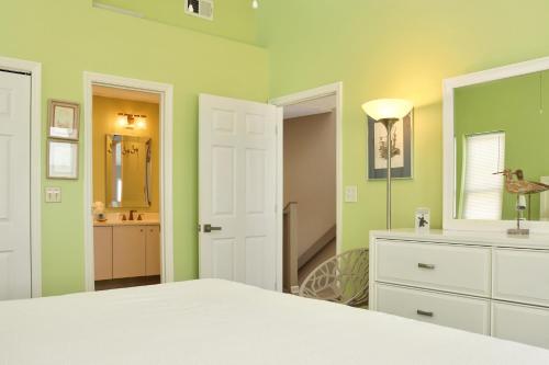 a bedroom with green walls and a bed and a bathroom at Indian Summer by Pristine Properties Vacation Rentals in Indian Pass