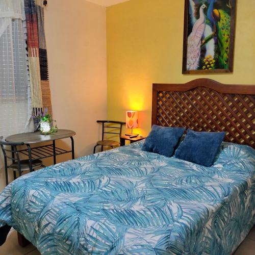 a bedroom with a bed with a blue comforter at HabitacionSUPER4 2 personas Casa SFco in Zacatlán