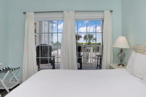 a bedroom with a white bed and a large window at Dunes Club 1A by Pristine Properties Vacation Rentals in Cape San Blas