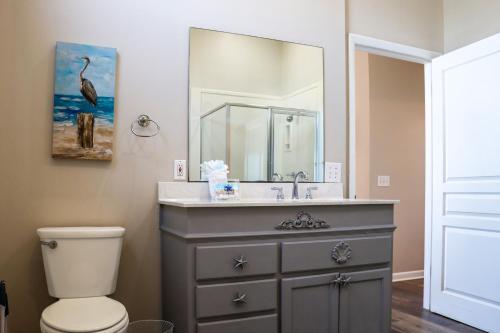 a bathroom with a sink and a toilet and a mirror at WindScape by Pristine Properties Vacation Rentals in Indian Pass