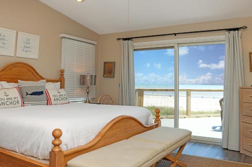a bedroom with a bed and a sliding glass door at WindScape by Pristine Properties Vacation Rentals in Indian Pass