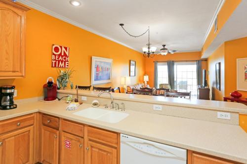 a kitchen with a sink and an orange wall at Dunes Club 1C by Pristine Properties Vacation Rentals in Cape San Blas