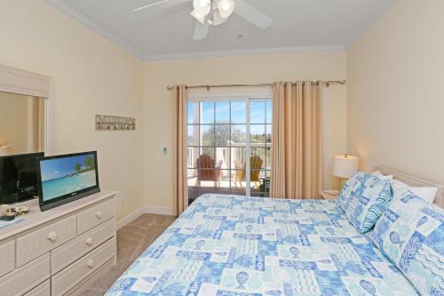 a bedroom with a bed and a flat screen tv at Dunes Club 1C by Pristine Properties Vacation Rentals in Cape San Blas