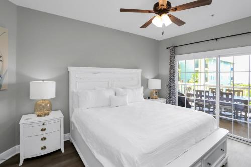 a bedroom with a white bed and a ceiling fan at Dunes Club 2A by Pristine Properties Vacation Rentals in Cape San Blas