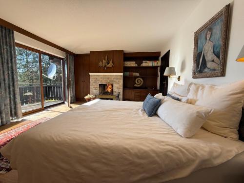 a bedroom with a large white bed with a fireplace at Die Landhausvilla in Unterach am Attersee in Unterach am Attersee