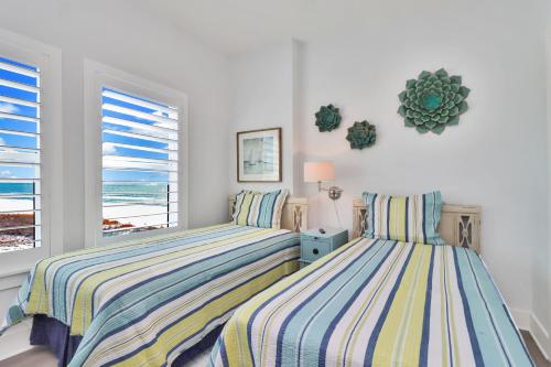 two beds in a bedroom with a view of the ocean at The Vue 2C by Pristine Properties Vacation Rentals in Mexico Beach