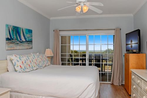 a bedroom with a white bed and a large window at Dunes Club 1D by Pristine Properties Vacation Rentals in Cape San Blas