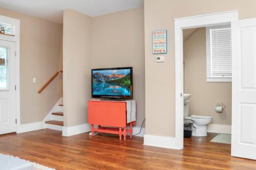 a living room with a tv on top of a cabinet at Barefoot Cottage B37 by Pristine Properties in Highland View