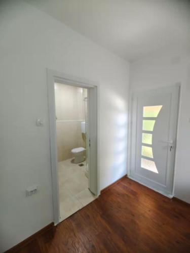 a room with a bathroom with a toilet and a door at Pavle Petra apartments in Mitrovići