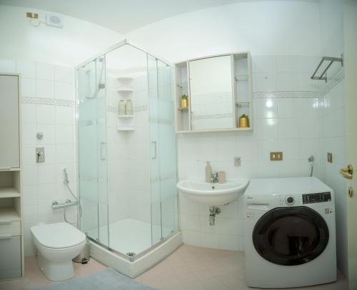 a bathroom with a toilet sink and a washing machine at Casa Loren in Novara